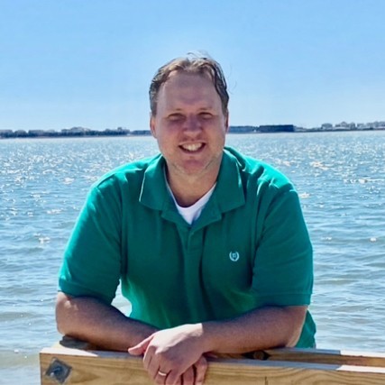 Aaron Sims standing by the ocean